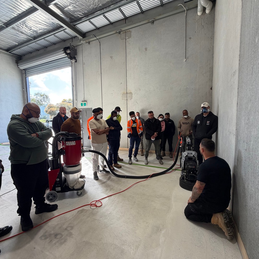 Trainer demonstrating concrete grinding equipment in the training bay